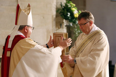 Fünf Männer zu Ständigen Diakonen geweiht: Bischof übergibt neuem Diakon das Evangelium. 