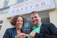 Preacher-Slam im Kino: Sibylle Kühn vom „Forum am Dom“ und Moderator Urs von Wulfen präsentieren den „Osnabrücker Löwenpudel“, der beim vierten Prediger-Wettbewerb am 20. September im Osnabrücker Hasetor-Kino zu gewinnen ist.