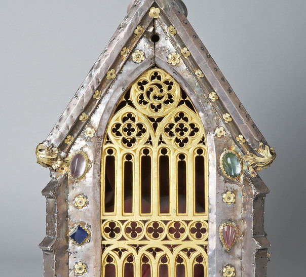Das gotische Maßwerk gibt den Blick frei auf die in kostbaren Stoffen gehüllten Reliquien.